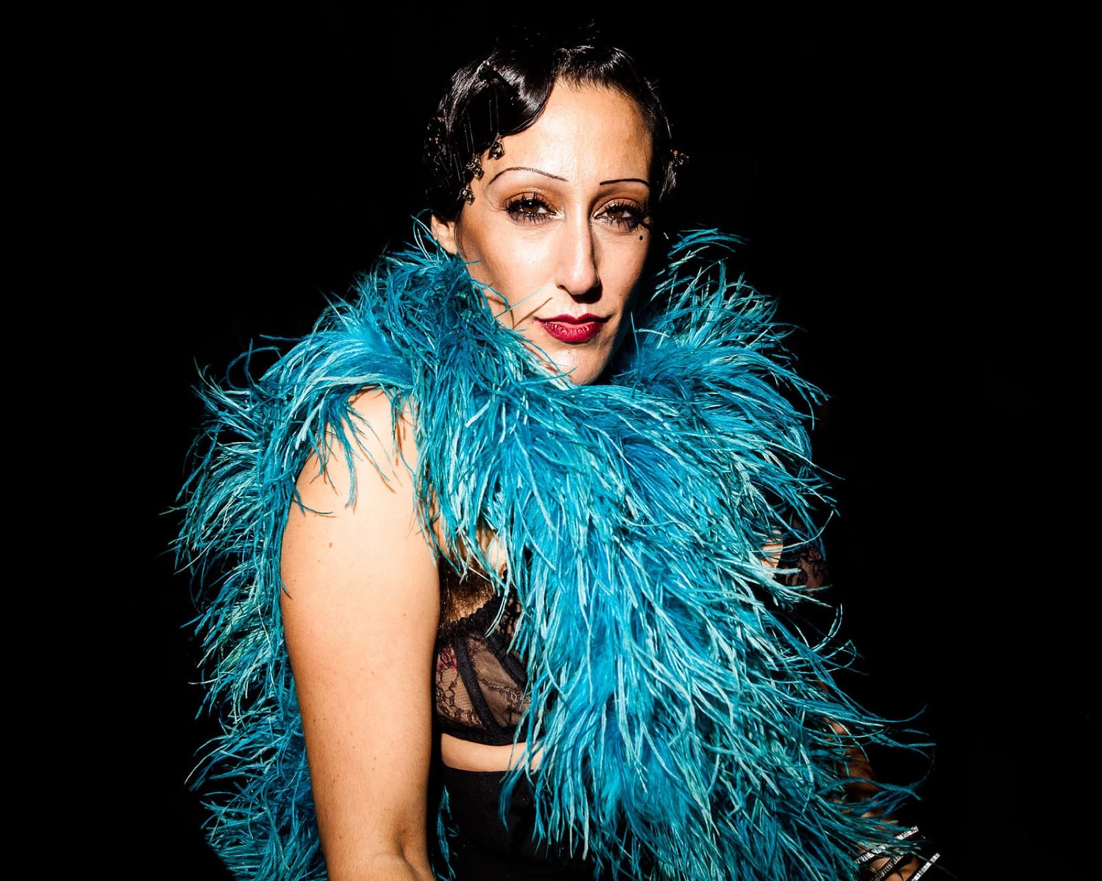 Performer in a teal feather boa at Battle Hymn, New York