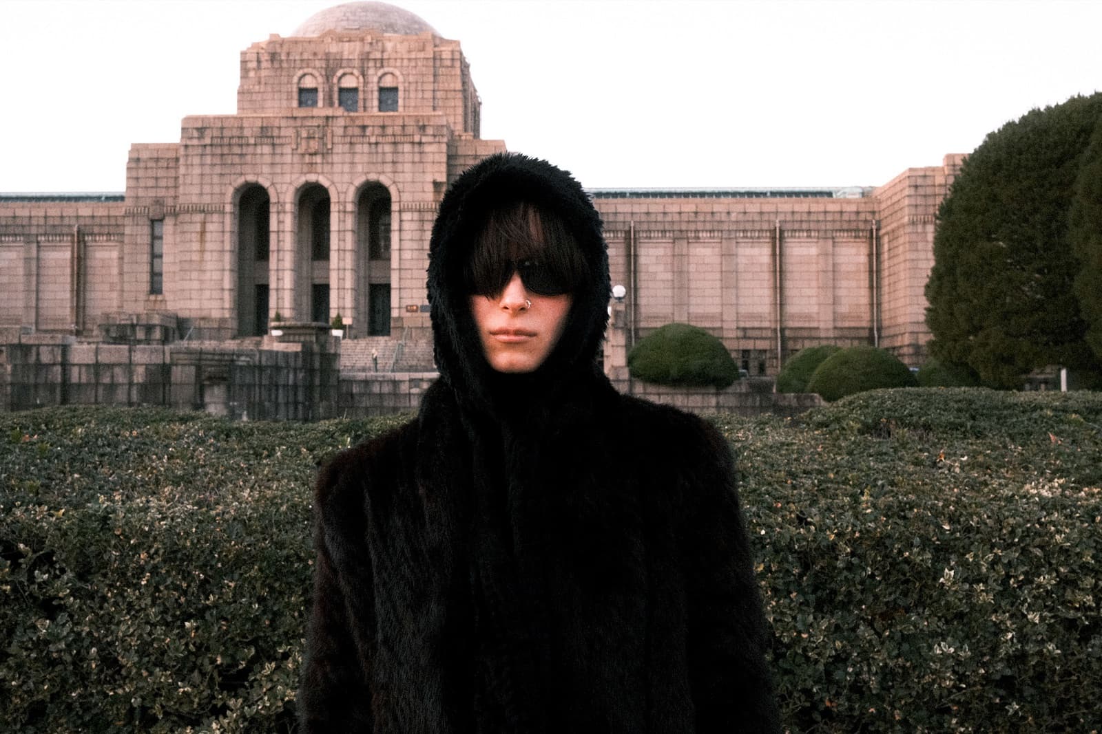 Fur hood and sunglasses outside a Tokyo monument